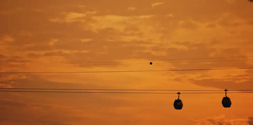 Cable car suspended over Singapore's harbor at dusk